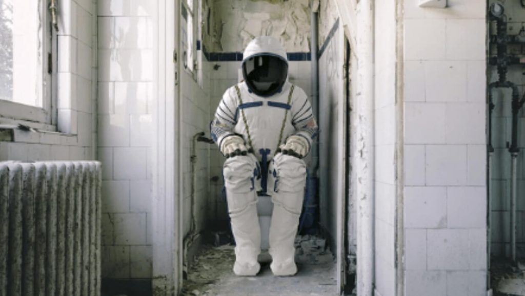 Spaceman sitting on a toilet